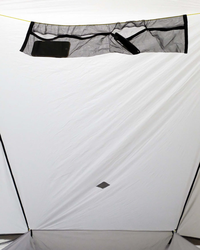 Internal gear loft inside of the Owyhee shelter.  Holding a phone and a pocket knife.