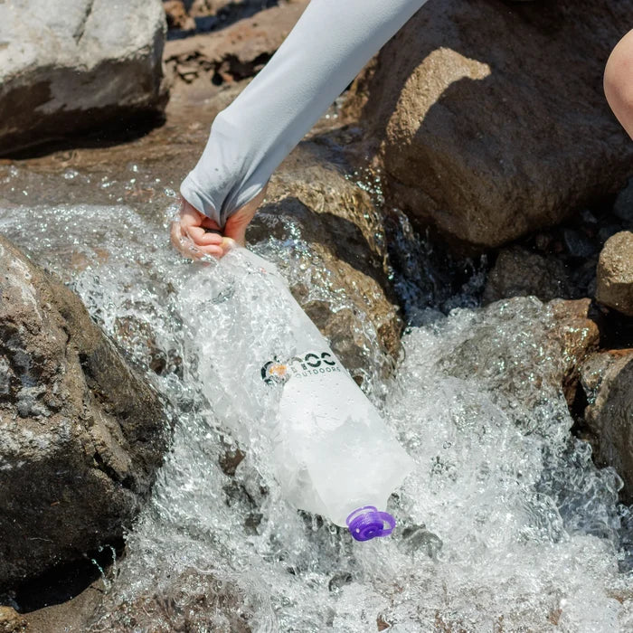 Cnoc Vecto X with purple lid being filled from a rushing mountain stream