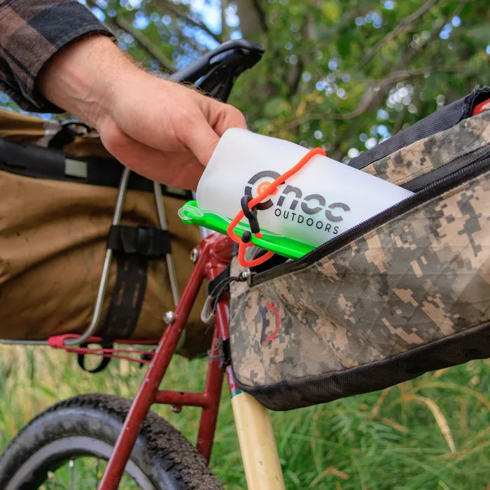 Cnoc Vecto rolled up and being put into the frame bag of a bike.