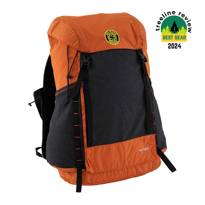 Wy'east backpack in orange with a white background.  Also showing an award from Treeline review for Best Gear 2024